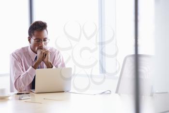 Businessman Working On Laptop At Boardroom Table