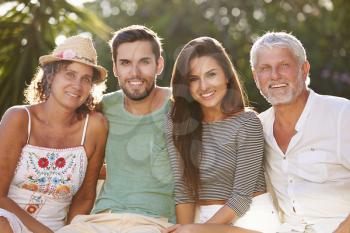 Parents With Adult Offspring Relaxing In Garden Together