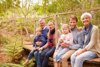 Multi-generation family portrait on a bridge in a forest