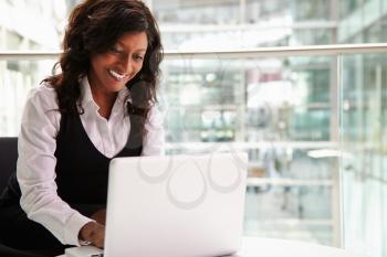 Mixed race businesswoman using laptop computer