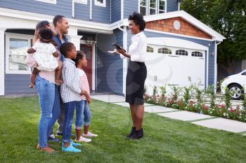 Real estate agent showing a family a house