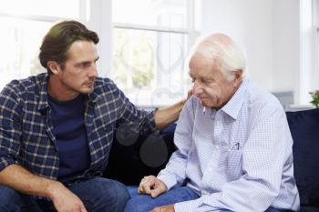 Adult Son Talking To Depressed Father At Home