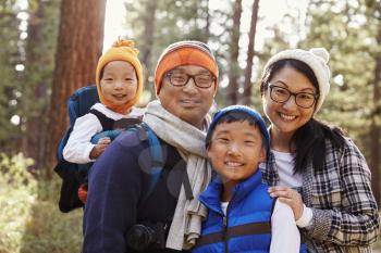 Portrait of an Asian family of four in a forest setting