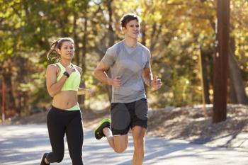 Caucasian woman and man jogging on a country road, close up