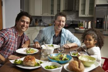 Male couple and black daughter dining at home look to camera