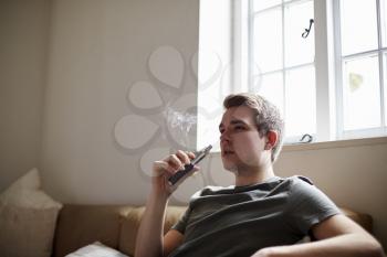 Young Man Using Vapourizer As Smoking Alternative