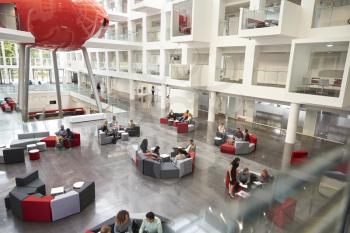 Students in a modern university atrium, view from mezzanine