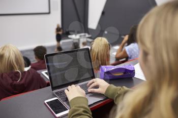 Female student using laptop at a university lecture