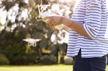 Close Up Of Woman Flying Drone Quadcopter In Garden