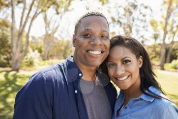 Outdoor Head And Shoulders Portrait Of Couple In Park