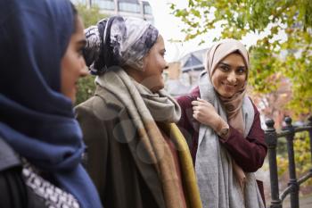 British Muslim Female Friends Meeting In Urban Environment