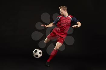 Professional Soccer Player Shooting At Goal In Studio