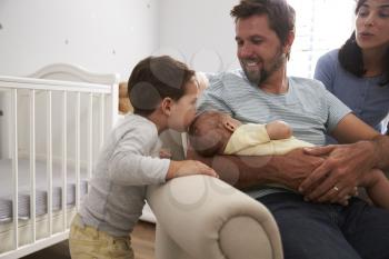 Family With Son And Newborn Brother In Nursery