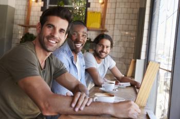 Portrait Of Three Male Friends Meeting In Coffee Shop
