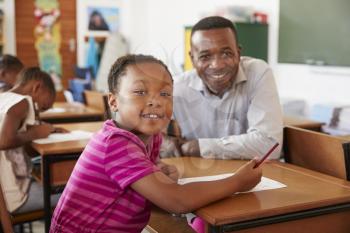 Black teacher and elementary school girl smiling to camera