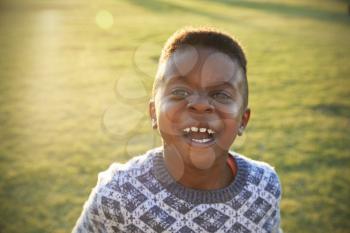 African elementary school boy laughing to camera outdoors
