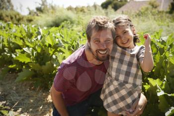 Portrait Of Father And Daughter Standing On Community Allotment