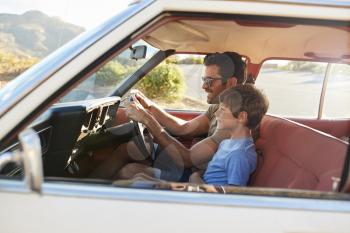 Father And Son In Front Seat Of Car On Road Trip