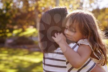 Loving Mother Hugging Daughter In Park