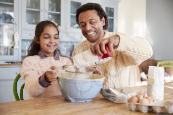 Father And Daughter Baking Cookies At Home Together