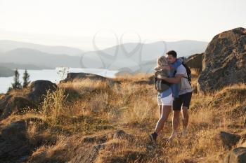 Couple Hugging On Top Of Hill On Hike Through Countryside In Lake District UK