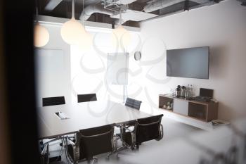 Chairs Around Boardroom Table In Empty Modern Meeting Room