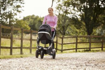 Mother Exercising By Running Whilst Pushing Baby Buggy