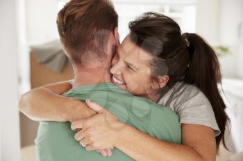 Loving Couple Celebrating With A Hug At Home