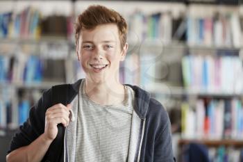 Portrait Of Male Student Standing In College Library