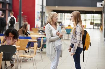 Teacher Talks To Student In Communal Area Of College Campus