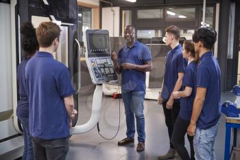 Engineer Showing Apprentices How To Use CNC Tool Making Machine