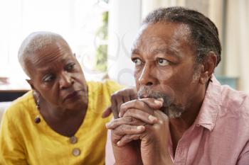 Senior Woman Comforting Man With Depression At Home