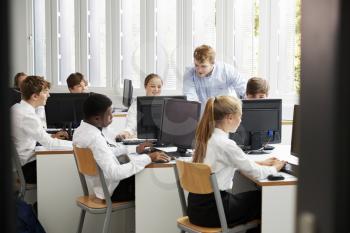 Teenage Students Wearing Uniform Studying In IT Class