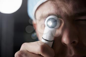 Male doctor using otoscope for examination