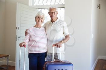 Portrait Of Senior Couple Arriving At Summer Vacation Rental
