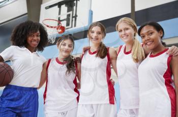 Portrait Of High School Basketball Coach With Female Team
