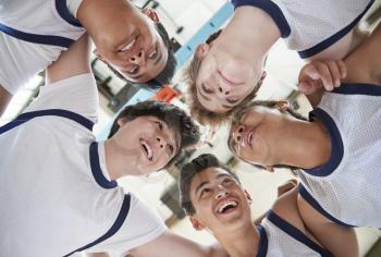 Low Angle View Of Male High School Basketball Players Having Team Talk