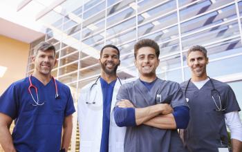 Male healthcare colleagues standing outdoors, low angle