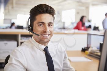 Hispanic male call centre worker smiling to camera, close-up
