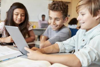 Elementary school boys using tablet computer in school class