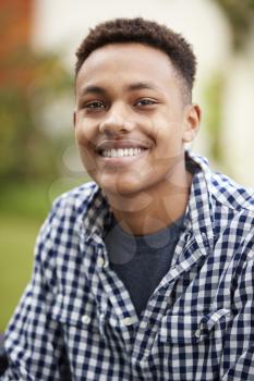 Young black man outdoors smiles to camera, close up, vertical