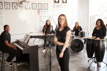 Portrait Of Students At Performing Arts School Playing In Band At Rehearsal