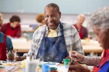 Portrait Of Retired Senior Man Attending Art Class In Community Centre