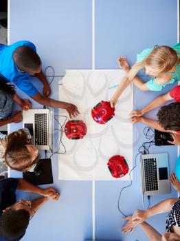 Overhead View Of Students In After School Computer Coding Class Learning To Program Robot Vehicle