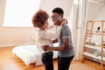 Couple Having Fun In New Home Dancing Together