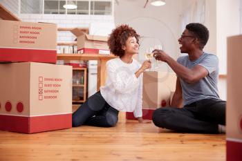 Couple Celebrating Moving Into New Home Drinking Champagne