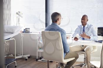 Mature Male Patient In Consultation With Doctor In Office