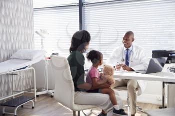 Mother And Daughter In Consultation With Doctor In Office