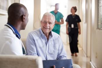 Doctor Welcoming To Senior Male Patient Being Admitted To Hospital