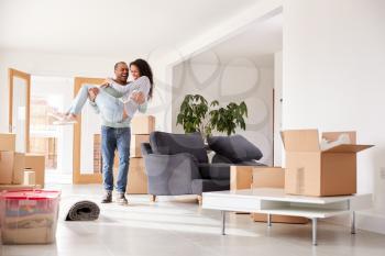 Man Carrying Woman Over Threshold Of New Home On Moving Day
